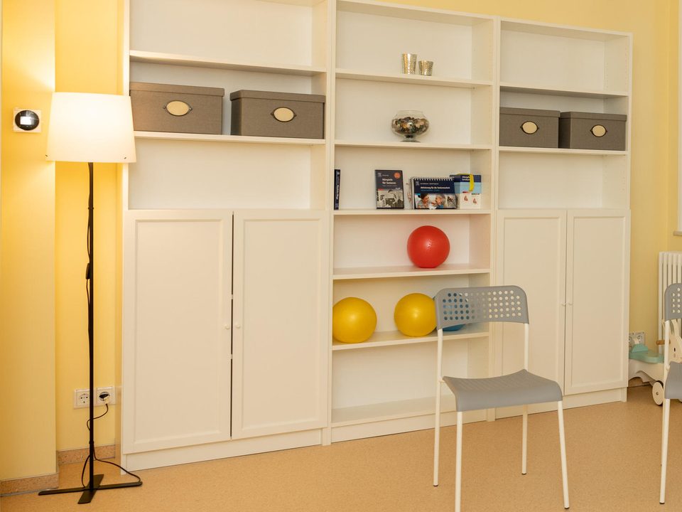 Therapieraum mit Regalen, Gymnastikbällen und Stühlen